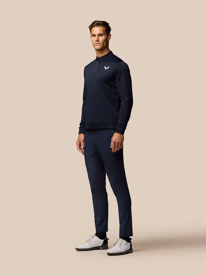 Male model wearing midnight navy Golf Club Classic 1/4 Zip Top with stand collar and chest logo.