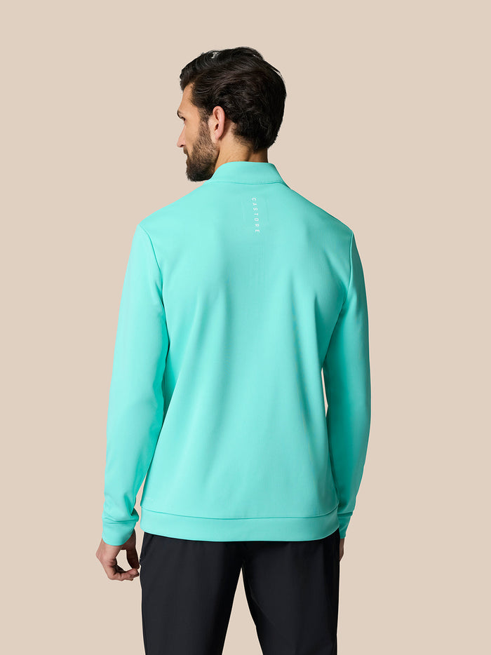 Back view of a man in light aqua Golf Club Classic Quarter Zip Top showing Castore branding on the upper back