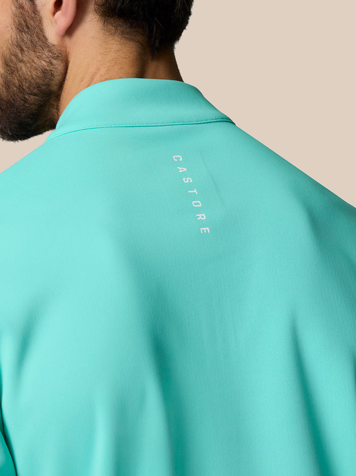 Back view of the light aqua Golf Club Classic Quarter Zip Top with Castore branding along the upper back