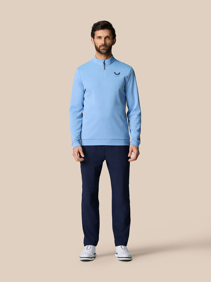 Man wearing sky blue Golf Club Classic Quarter Zip Top with stand collar and front zip, Castore logo on left chest
