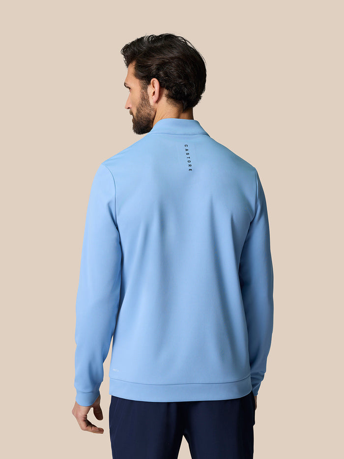 Back view of a man in sky blue Golf Club Classic Quarter Zip Top showing vertical Castore branding down the back