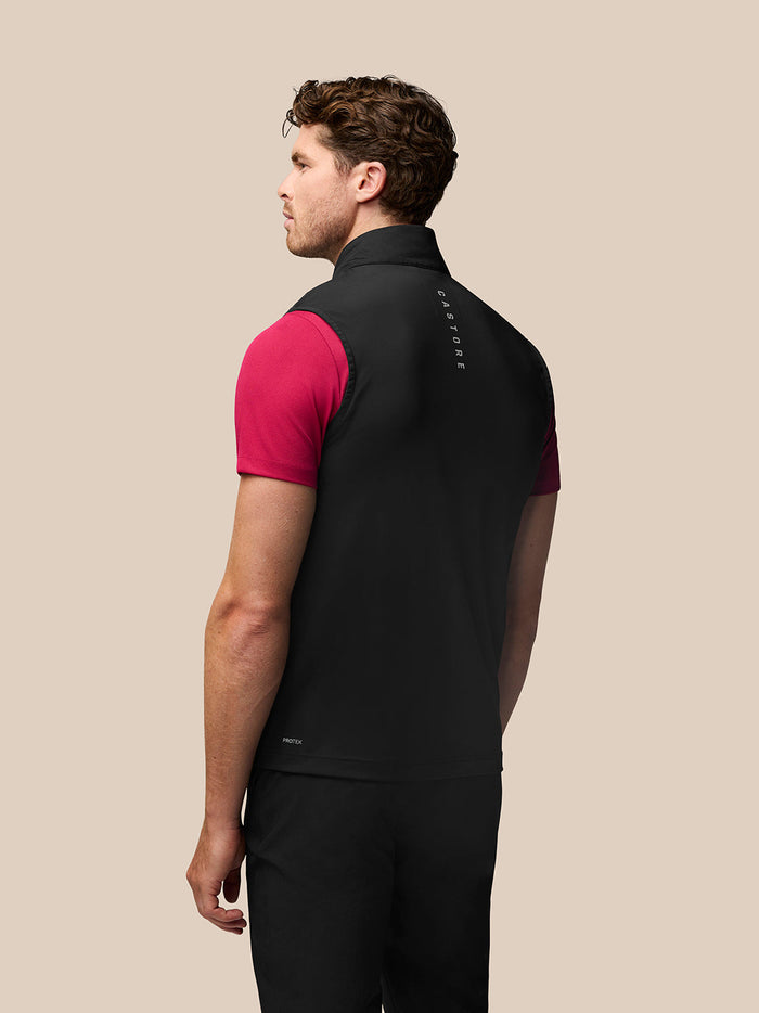 Back view of a man wearing a black Golf Pinnacle Gilet with pink sleeves and branding along the collar and upper back.