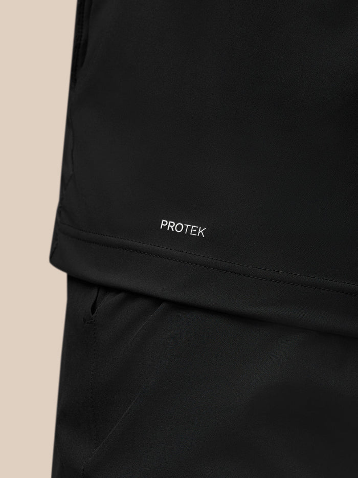 Close-up of the lower back of the black Pinnacle Gilet with PROTEK branding near the hem
