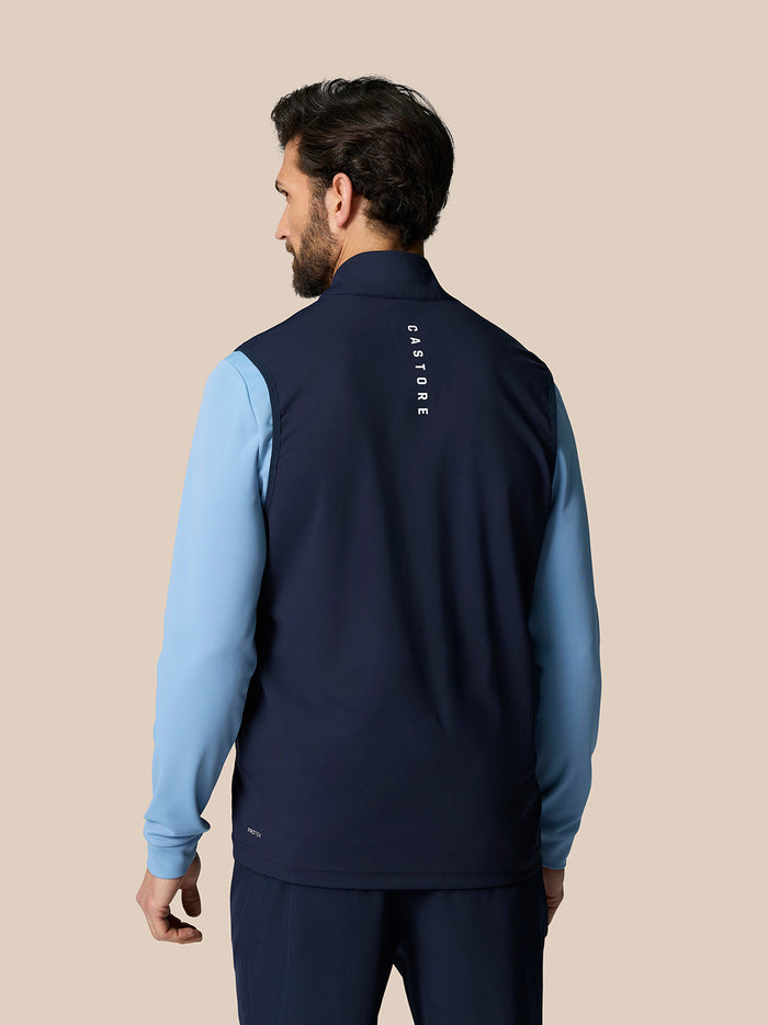 Back view of male model in navy Pinnacle Gilet with Castore branding on the upper back