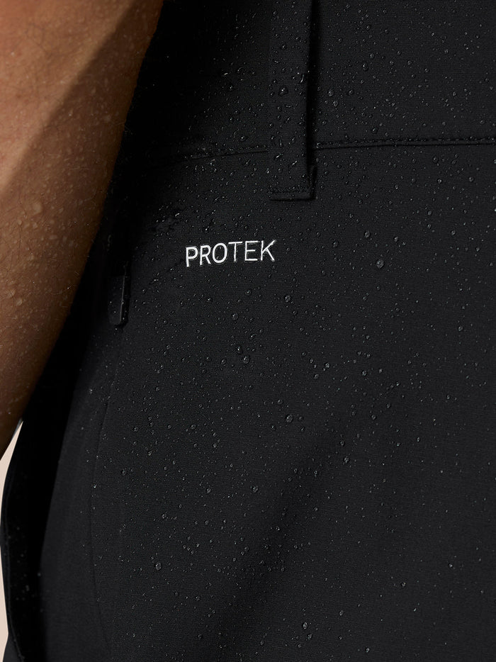 Black golf trousers close-up showing Castore branding on the right thigh and rear.