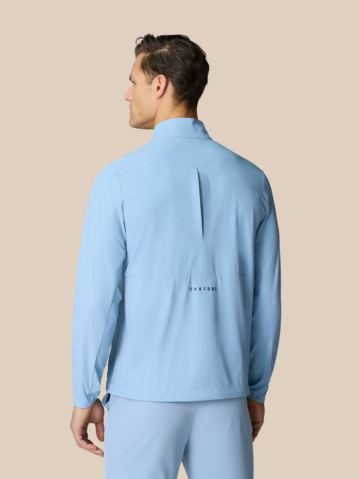 Back view of sky blue Golf Flex Jacket with vertical back opening and Castore logo across the lower back