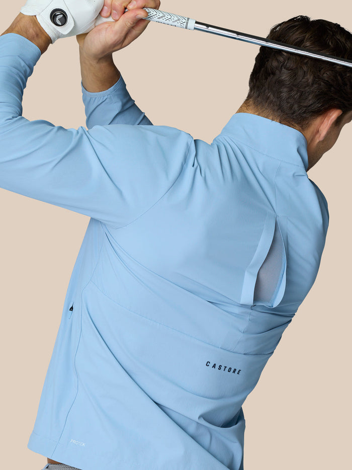 Back view of sky blue Flex Woven Half Zip golf jacket with Castore logo on left side and back and ProTek branding at the hem