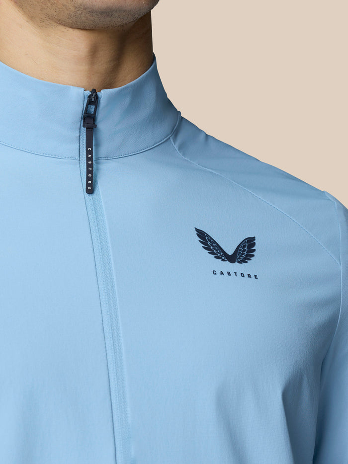 Detail of a sky blue Golf Flex Jacket with front zipper and Castore logo on the chest.
