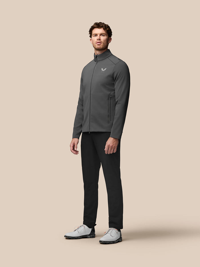 Full-body shot of a man modeling the charcoal Garcia Hybrid Jacket with zip front and side pockets.