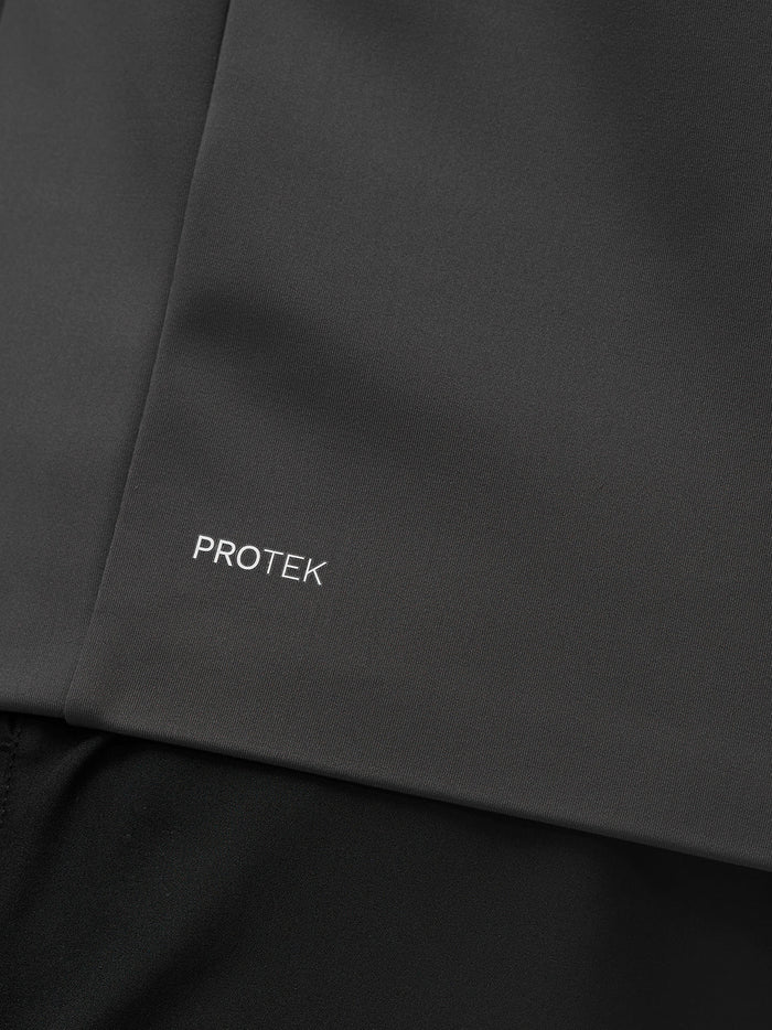 Close up of charcoal Garcia Hybrid Jacket fabric with Protek branding near the hem.