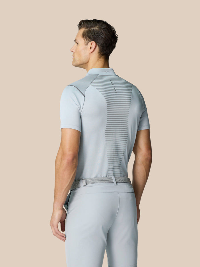 Back view of a male model wearing the Pinnacle Golf LVS Polo in mid grey with bodymapped panels.