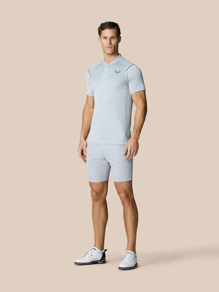 Male model wearing light grey Pinnacle Golf LVS Polo with vented knit panels and left chest logo