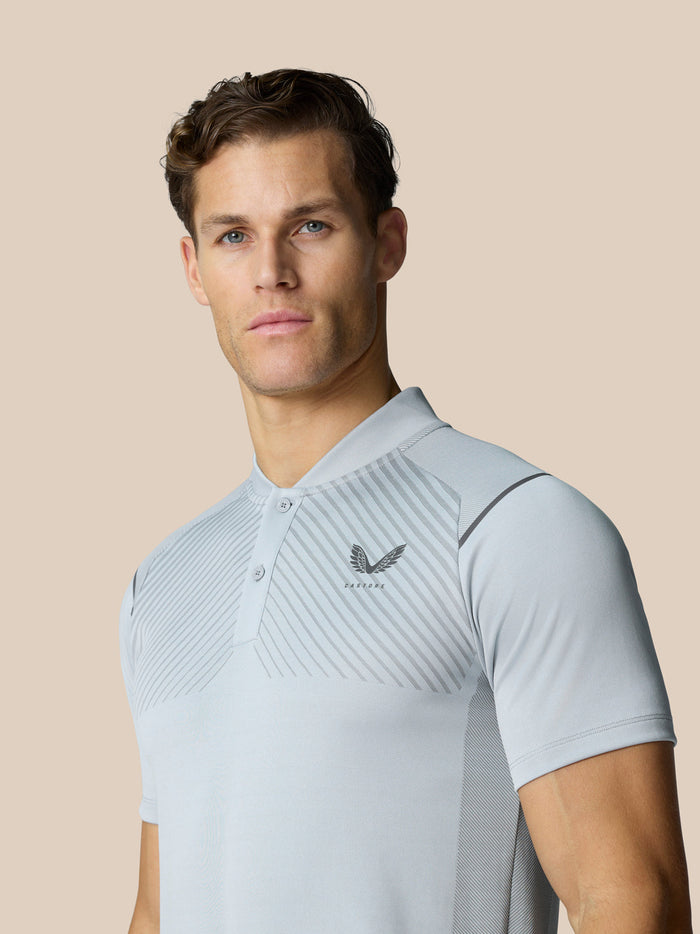 Front view of a man in Pinnacle LVS Polo mid grey with diagonal chest stripes.