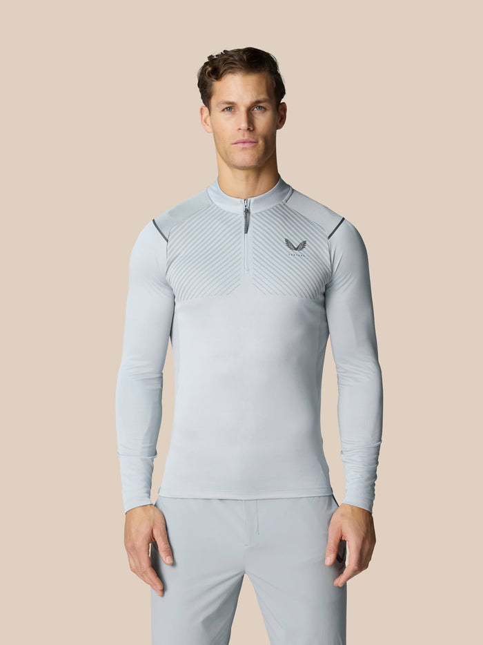 Front view of a man in a light grey Pinnacle LVS quarter zip top with venting stripes on the chest and shoulders.