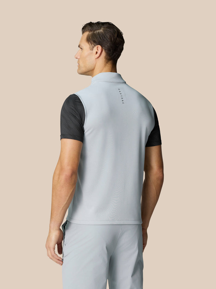 Rear view of a light grey Club Classic half zip golf gilet on a male model with Castore branding along the back.