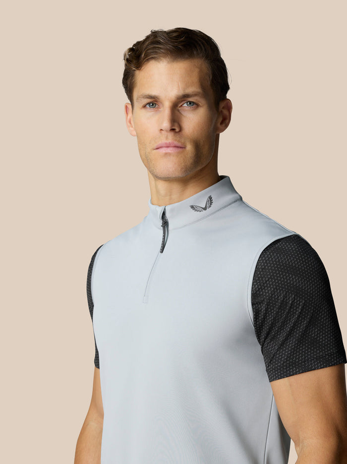 Close-up of a male model in a light blue stand collar half zip golf top with dark patterned sleeves