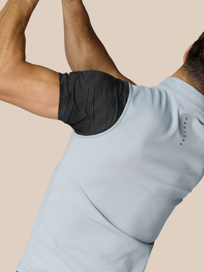 Close up of a man wearing a light blue golf gilet with a dark dotted underarm panel