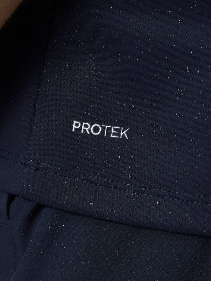 Close-up of navy Club 1/2 Zip Gilet fabric with water droplets and PROTEK branding