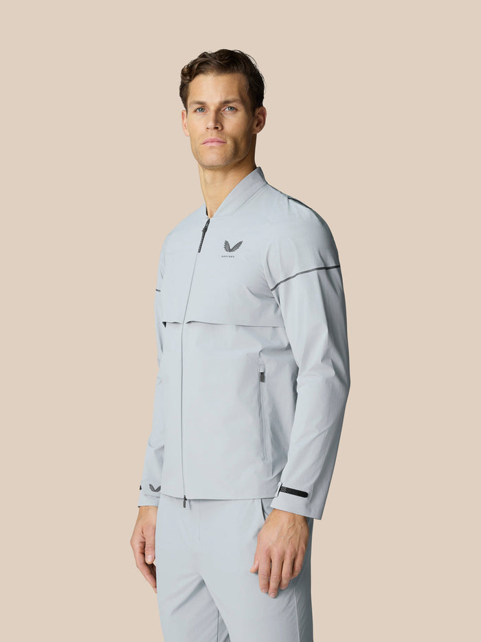 Male model in light grey LVS Woven Jacket with zip pockets and dropped hem standing in profile