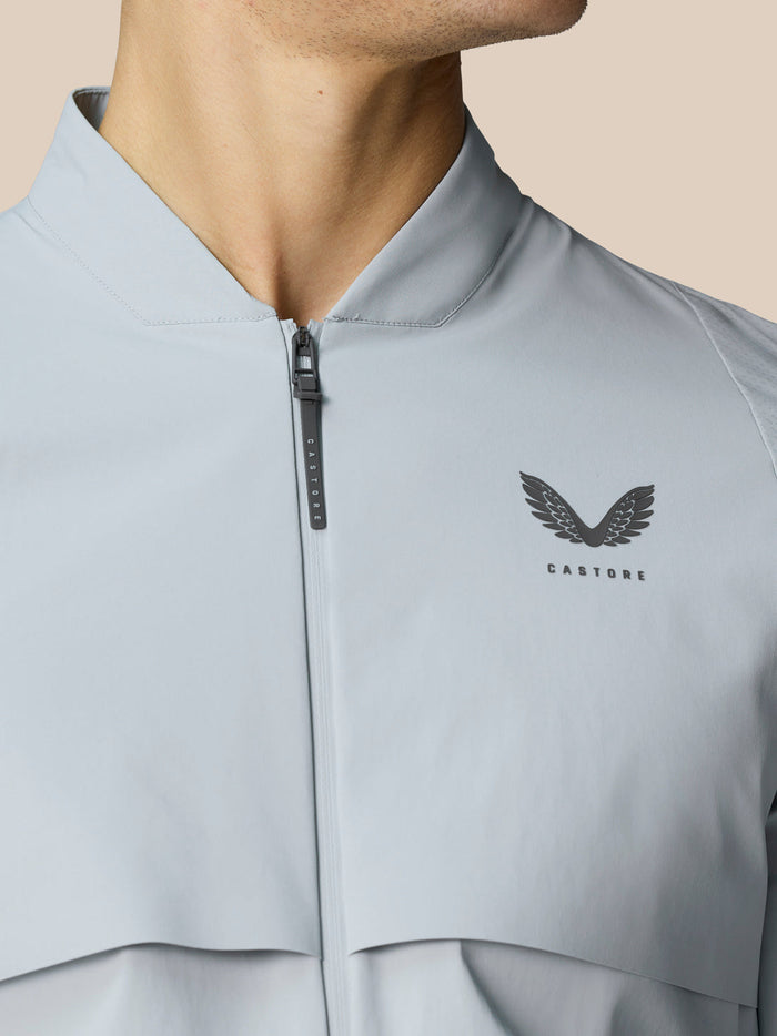 Close-up of the Golf Pinnacle LVS Woven Jacket in mid grey with front zipper and Castore logo on the chest