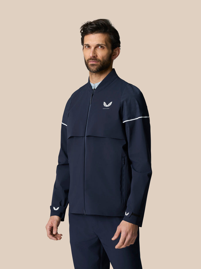 Male model wearing Golf Pinnacle LVS Woven Jacket in midnight navy front view with chest logo