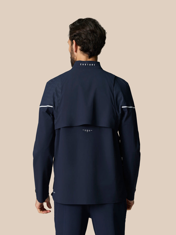 Male model wearing Golf Pinnacle LVS Woven Jacket in midnight navy back view with CASTORE branding on the collar