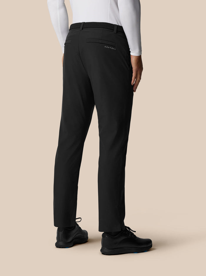 Back view of a male model in black Golf Pinnacle Winter Trousers showing back pockets with Castore branding.
