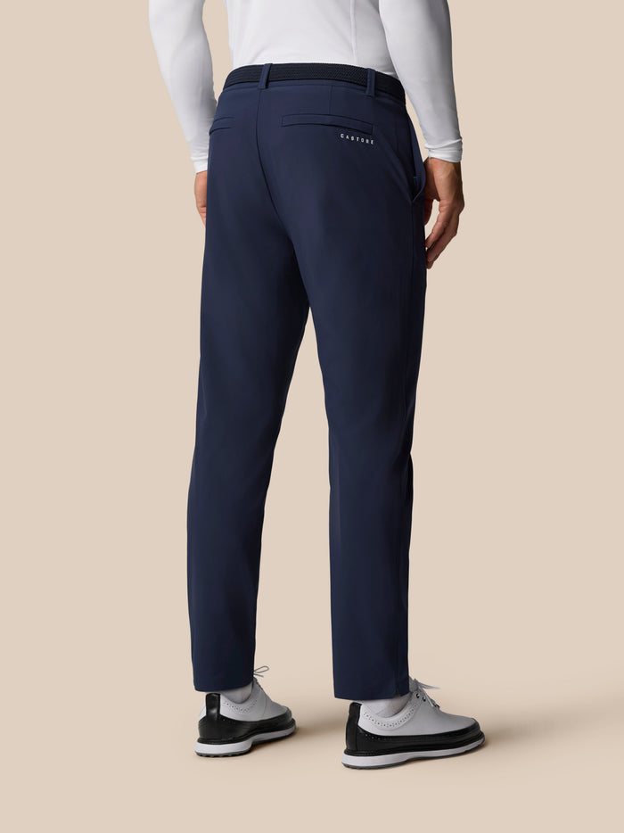 Back view of a person in navy Golf Pinnacle Winter Trousers with Castore branding on the back pocket and a white top.