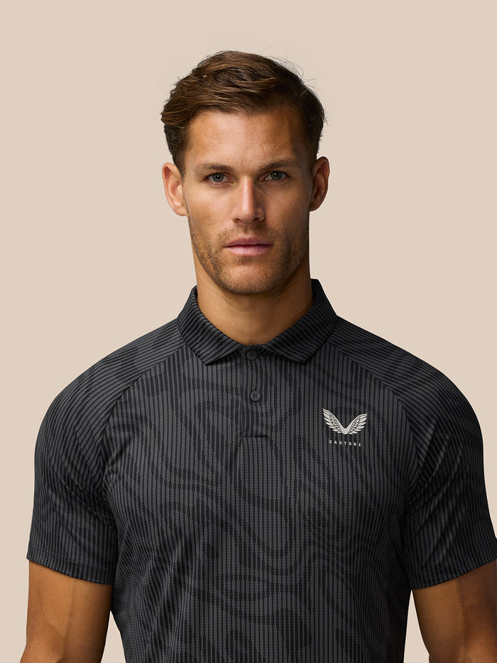 Male model wearing Golf Club Glow Printed Polo in gunmetal grey with a subtle pattern and Castore logo on the left chest