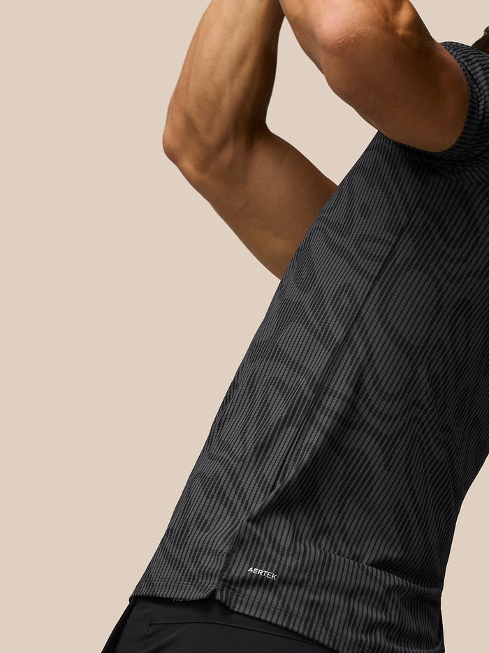 Close-up side view of Golf Club Glow Printed Polo in gunmetal grey showing AerTek fabric and side split hem.
