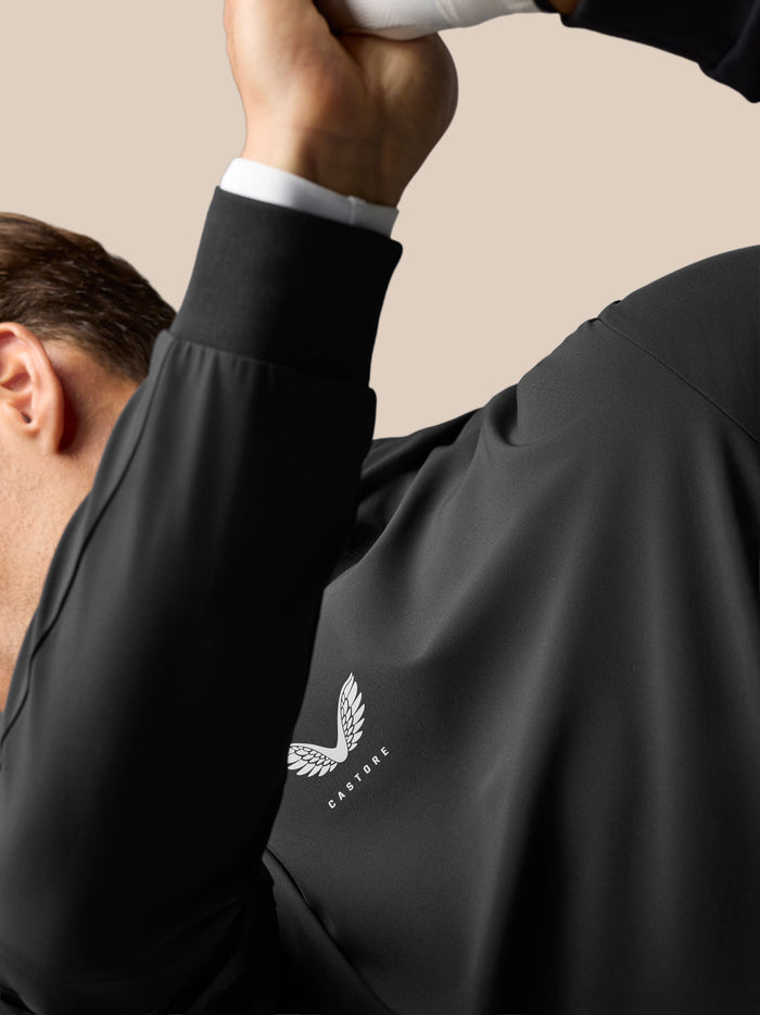Close-up of a man wearing the black Golf Pinnacle Performance Hoodie, chest logo visible and a three-panel hood