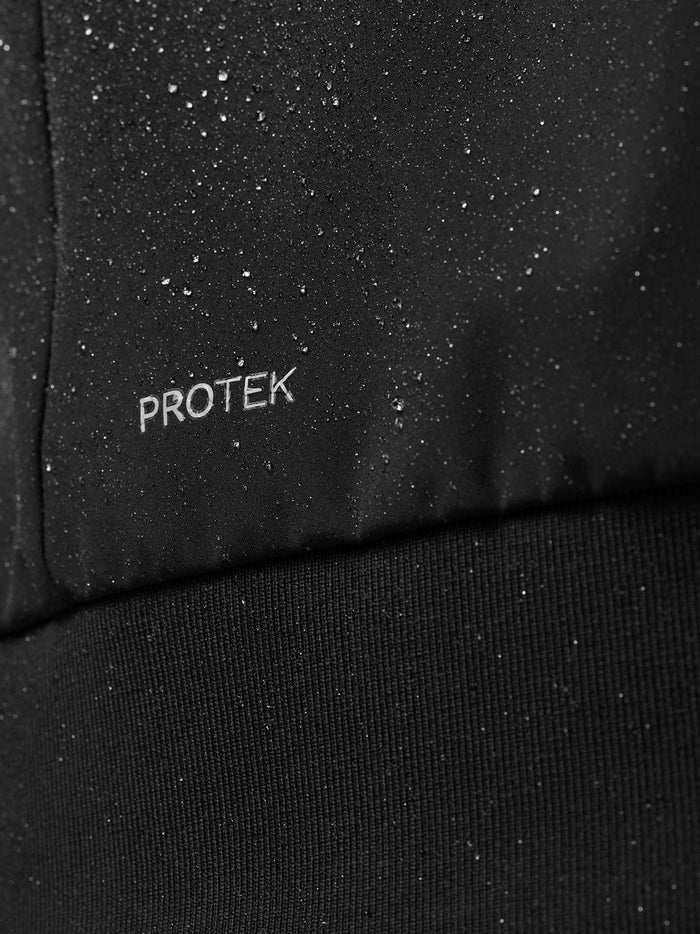 Close up of black fabric with water droplets and the PROTEK logo indicating water resistance