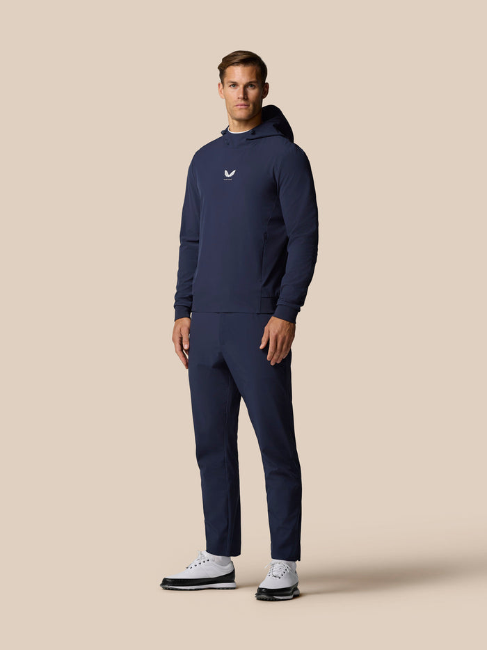 Full body front view of a male model in midnight navy golf hoodie with matching joggers and white sneakers.