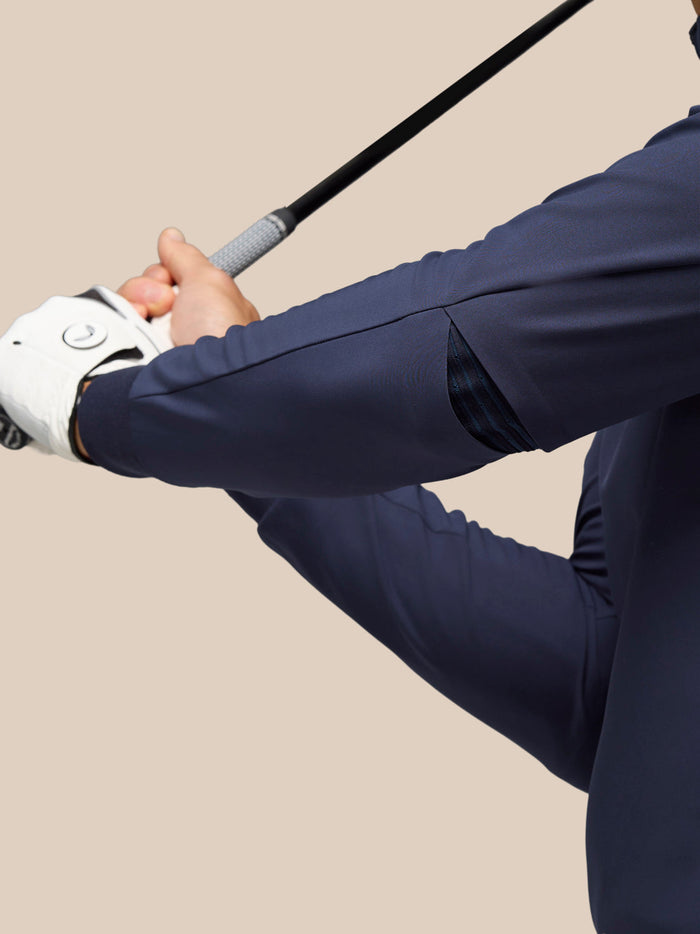 Rear view of navy Golf Pinnacle Performance Hoodie showing elasticated elbow panels for mobility while gripping a club