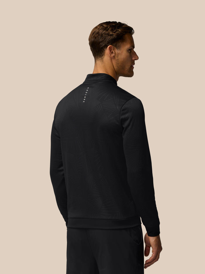 Back view of a man wearing the Castore Golf Club Classic 1/4 Zip Debossed Top in black with an allover print
