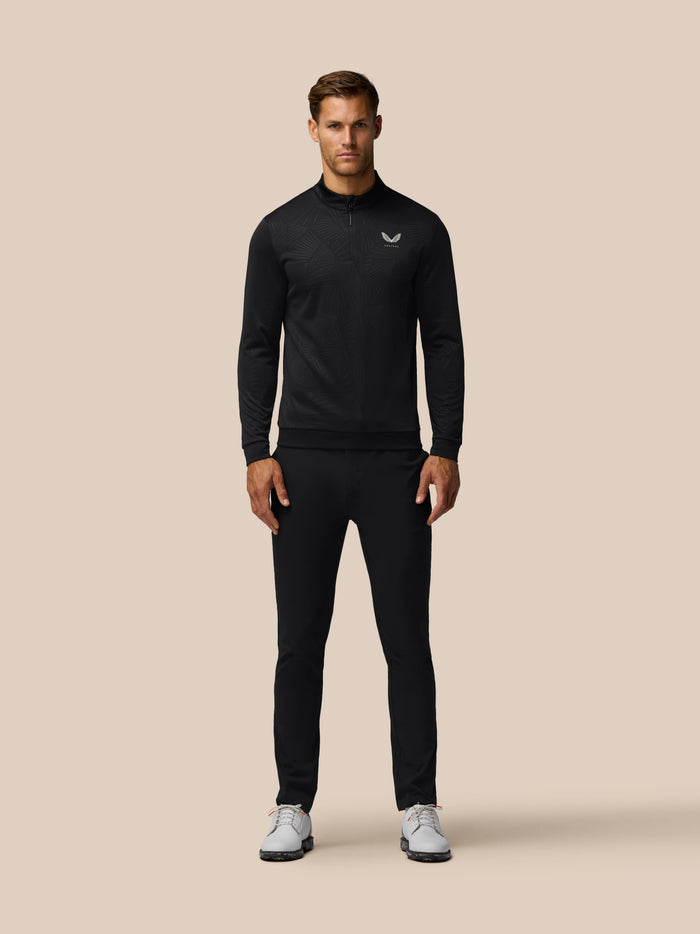 Front view of a man in black Golf Club Classic 1/4 Zip Debossed Top with all over print and Castore chest logo
