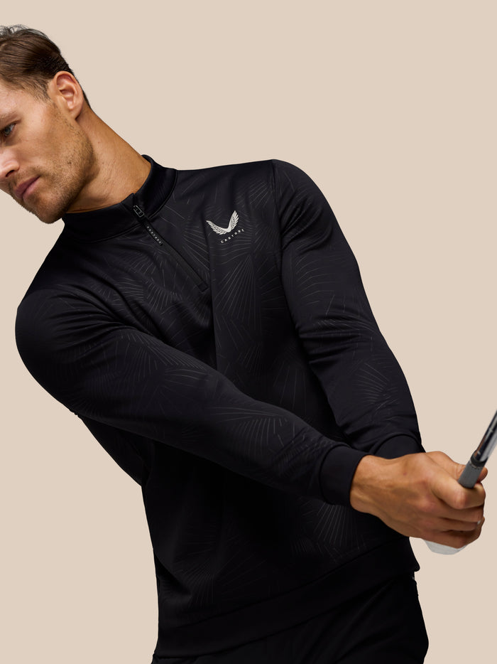 Side angle of a man in black Golf Club Classic 1/4 Zip Debossed Top highlighting the zip and subtle print