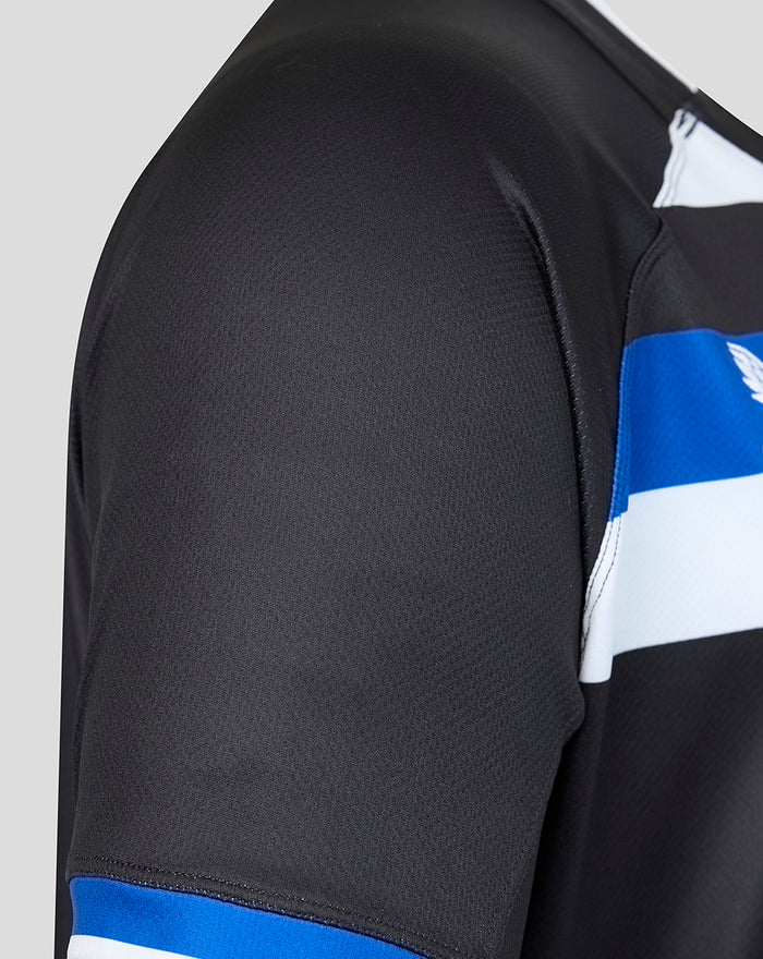 Close-up of black Bath Rugby home shirt sleeve with blue cuff stripe and textured fabric.