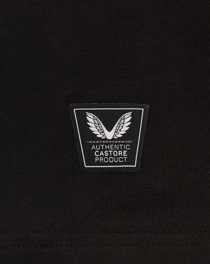 Close-up of black fabric with a square authentic Castore product patch featuring a wing emblem.