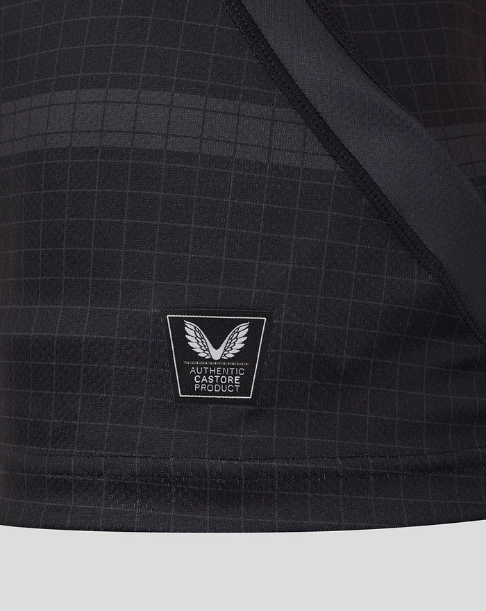 Close-up of dark grid-pattern Bath Rugby replica shirt fabric with authentic Castore product badge