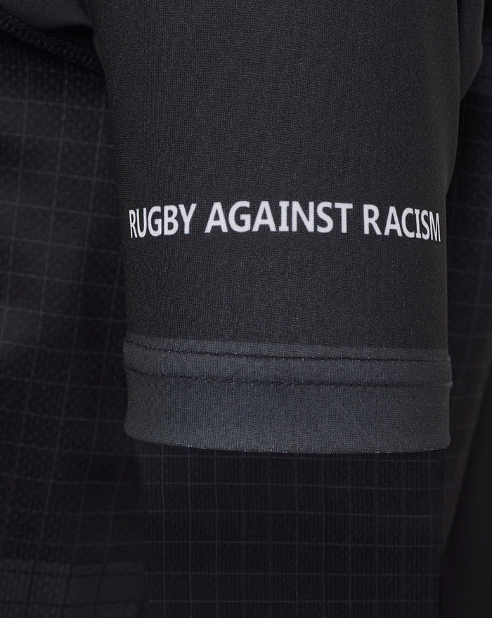 Sleeve close-up displaying Rugby Against Racism message on dark fabric