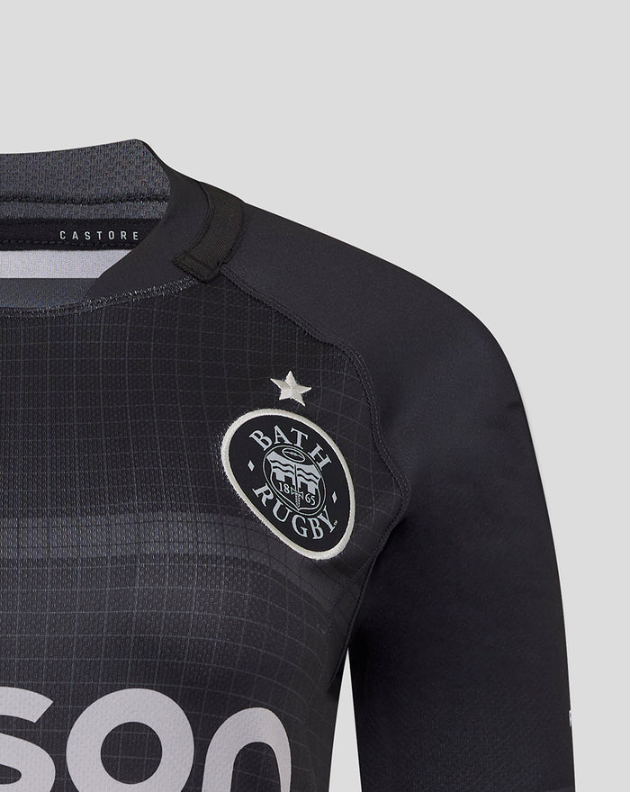 Close-up of Bath Rugby replica shirt chest showing crest on dark fabric with textured grid pattern