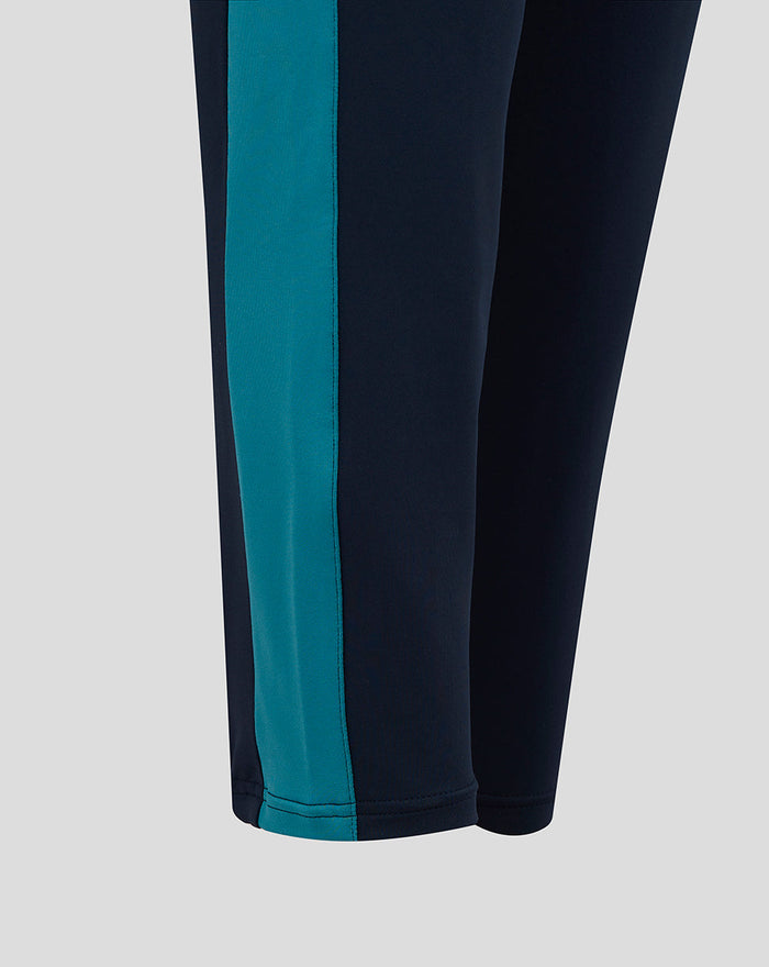 Close up of navy knit pants showing a teal contrast side panel along the leg.