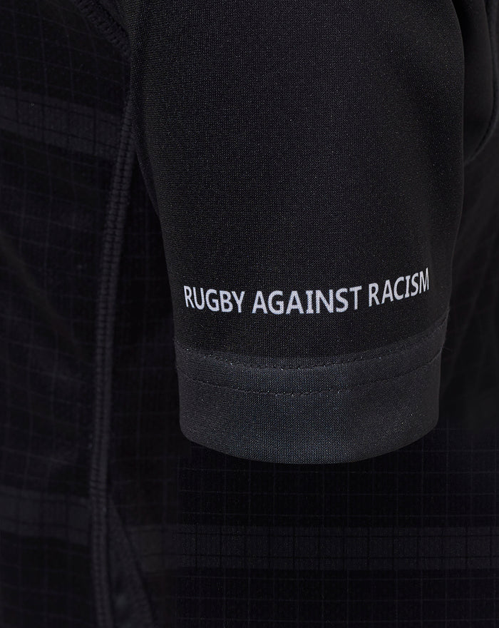 Close up of black Bath Rugby junior replica shirt sleeve with Rugby Against Racism text
