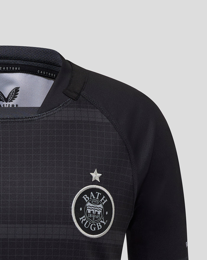 Close-up of Bath Rugby junior jersey chest showing crest and star on dark grid fabric