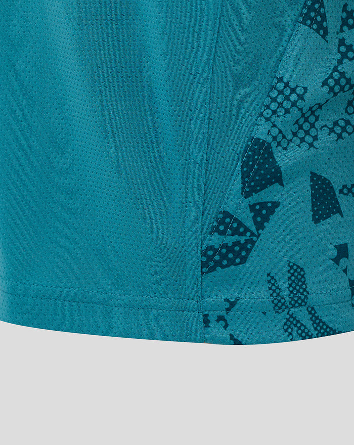 Close-up of storm blue junior England rugby tee highlighting abstract side panel print and teal fabric near hem.