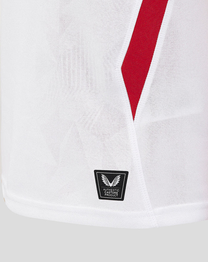 Close up of white junior England rugby shirt showing a red diagonal stripe and a Castore product badge near the hem