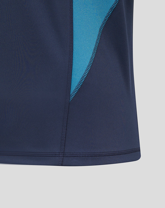 Close-up of the teal side panel contrasting with navy fabric on the rugby drill top.