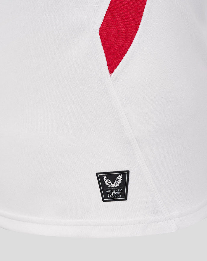 Detail of lower side panel on white England rugby shirt with red side insert and Castore authentic product badge near the hem