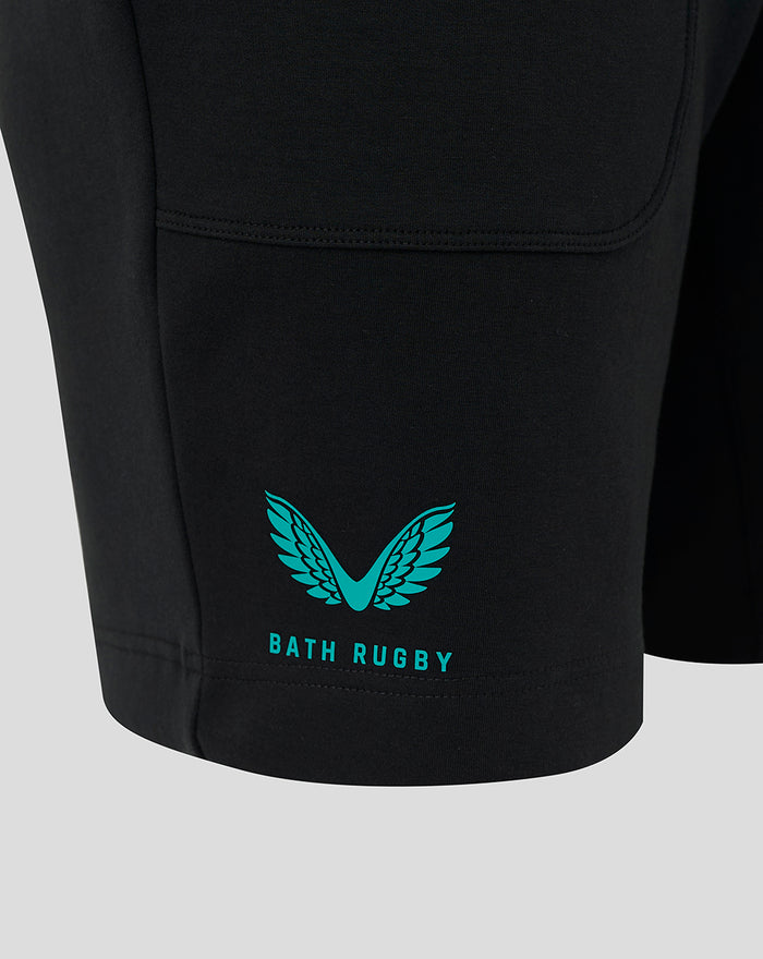 Teal winged Bath Rugby logo near the hem of a black shorts leg.